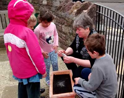 Children planing poppy seeds with the Minister.