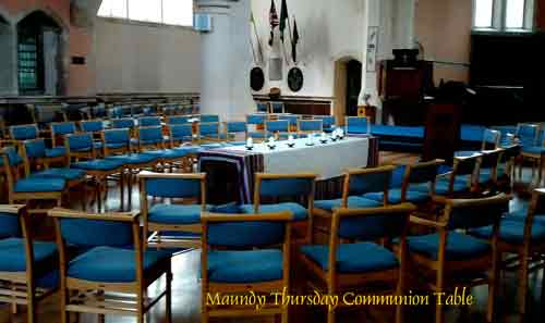Church laid out with a circle of blue chairs around the communion table.